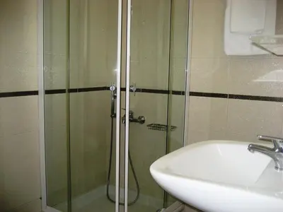 a shower with a glass door next to a sink at Yiorgos Studios in Palaiochóra