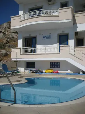 a house with a swimming pool in front of a building at Yiorgos Studios in Palaiochóra