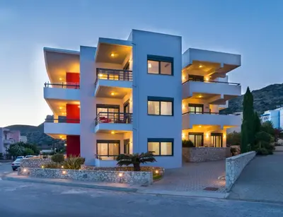 a white building with lights in front of it at Caravella Luxury Apartments in Palaiochóra