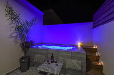 a purple room with a table and a swimming pool at Aretousa Suites in Chania Town