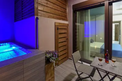a hot tub in a house with a table and chairs at Aretousa Suites in Chania Town