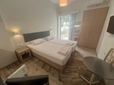 a small bedroom with a bed and a table and a tableablish at Neapolis Apartments in Palaiochóra