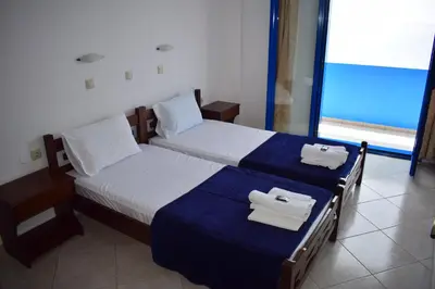 two beds in a hotel room with towels on them at Zorbas Studios in Agia Roumeli