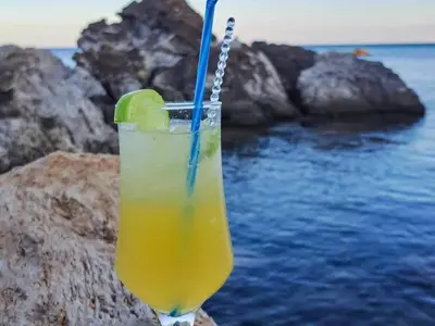 a drink with a lime and a blue straw at Haris Studios in Palaiochóra