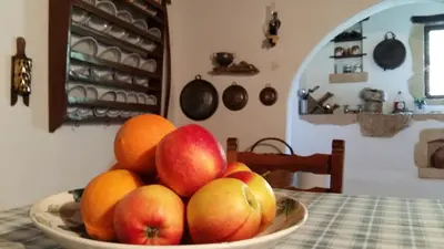 a bowl of apples and oranges on a table at Bendeni Cottage in Megála Khoráfia