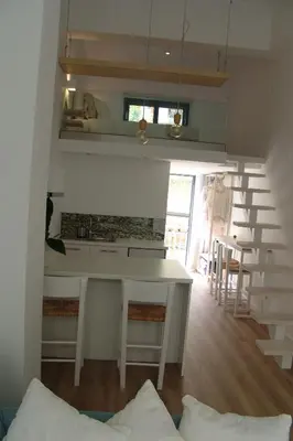a kitchen with a table and some chairs in a room at Sixteen All Seasons House in Chania Town