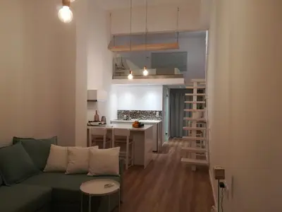 a living room with a green couch and a kitchen at Sixteen All Seasons House in Chania Town