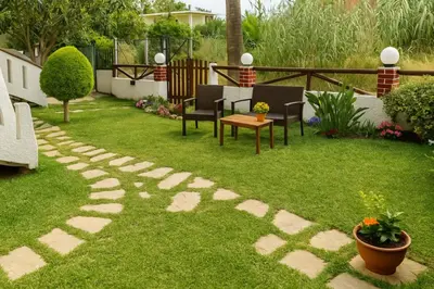 a garden with chairs and a table on the grass at Nicolas Beach in Palaiochóra
