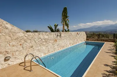 a swimming pool in a stone wall with a swimming pool at Villa Anemi in Stérnai