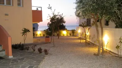 a courtyard of a building at night with lights at Iolkos Hotel Apartments in Kato Daratso