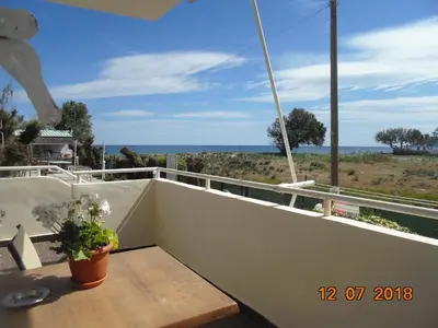 a balcony with a table and a view of the ocean at Hippokratis Apartments in Gerani Chanion
