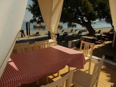a table and chairs on a beach with a table and a table and chairsearcher at Hippokratis Apartments in Gerani Chanion