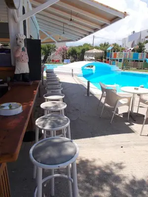 a row of stools in front of a swimming pool at Hippokratis Apartments in Gerani Chanion