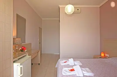 a hotel room with two beds with towels on them at Akrogiali in Kissamos