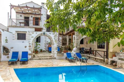 a villa with a swimming pool and a house at GrapeVine Villa in Gavalochori