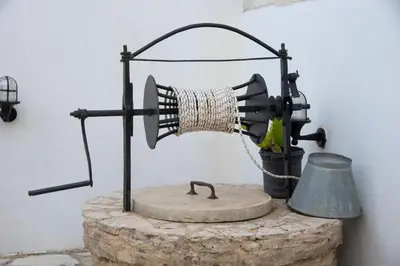 a grinding machine with a bell on a rock at GrapeVine Villa in Gavalochori