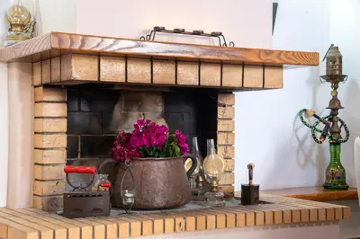 a brick fireplace with a pot of flowers in it at GrapeVine Villa in Gavalochori
