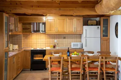 a kitchen with a table and a white refrigerator at GrapeVine Villa in Gavalochori