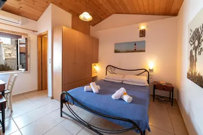 a bedroom with a blue bed with towels on it at GrapeVine Villa in Gavalochori