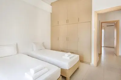 two beds in a room with white walls at Mirsini's Apartment in Chania center in Chania Town