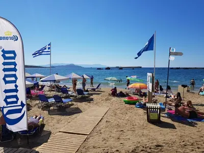 a group of people on a beach with flags at Mirsini's Apartment in Chania center in Chania Town
