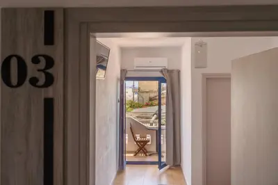 a hallway with a door leading to a balcony at Giannis Rooms in Agia Roumeli