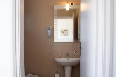 a bathroom with a sink and a mirror at Giannis Rooms in Agia Roumeli