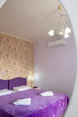 a bedroom with two beds and a purple blanket at Areti Suites in Kathiana