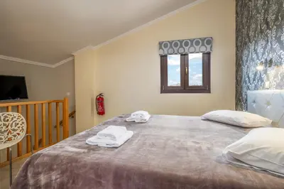 a bedroom with a large bed with towels on it at Areti Suites in Kathiana