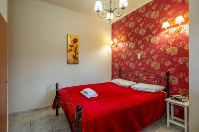 a bedroom with a red bed with a red wall at Areti Suites in Kathiana