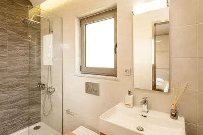 a bathroom with a sink and a shower and a mirror at Kagiemar Luxury House in Perivólia
