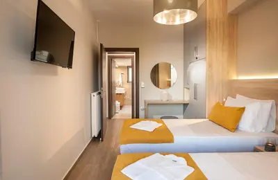 a hotel room with two beds and a television at Amaen Luxury House in Perivólia