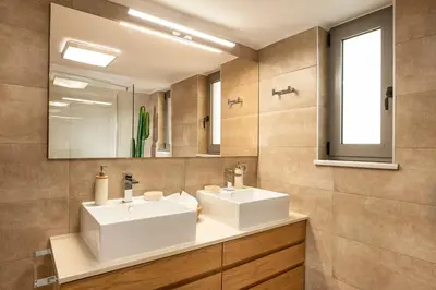 a bathroom with two white sinks and a mirror at Amaen Luxury House in Perivólia