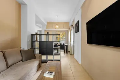 a living room with a couch and a flat screen tv at Casa Veranda - 3 Bedroom House with BBQ & Backyard in Chania Town
