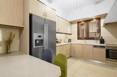 a kitchen with a refrigerator and a table with chairs at Casa Veranda - 3 Bedroom House with BBQ & Backyard in Chania Town