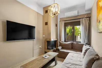 a living room with a couch and a flat screen tv at Casa Veranda - 3 Bedroom House with BBQ & Backyard in Chania Town