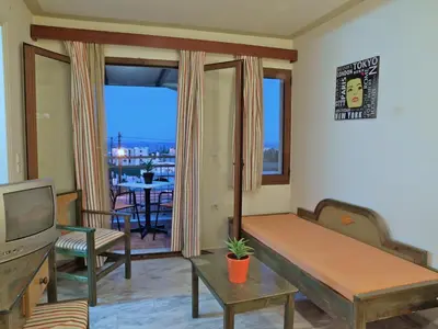 a living room with a couch and a tv at Alexandros M in Maleme