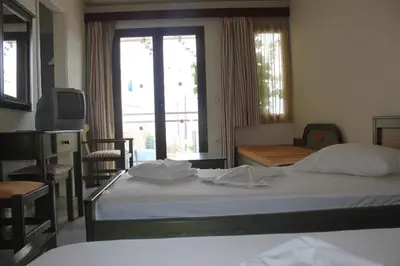 a hotel room with two beds and a television at Alexandros M in Maleme