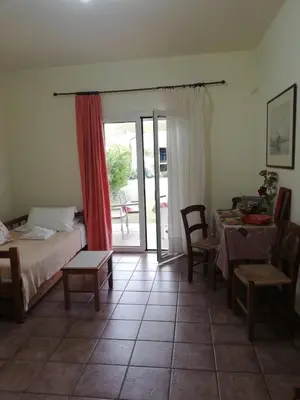 a bedroom with a bed and a table and a dining room at Kalithea Apartments - Heated Pool in Kalyves