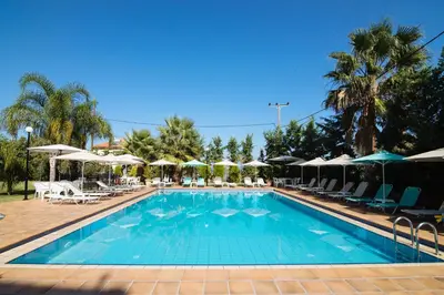 a swimming pool with chairs and umbrellas at Kalithea Apartments - Heated Pool in Kalyves