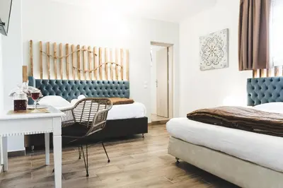 a bedroom with two beds and a table and a chair at Dome Rooms Downtown in Chania Town