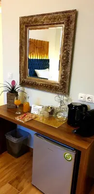 a mirror on the wall above a counter with a refrigerator at Dome Rooms Downtown in Chania Town