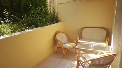 a balcony with two chairs and a table and a window at Marita's Apartments in Agia Marina Nea Kydonias