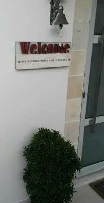 a sign on the side of a building with a bush at Ontas Villa Loutraki Platanias in Gerani Chanion