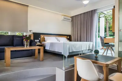 a hotel room with a bed and a couch at Forum Suites in Kato Daratso