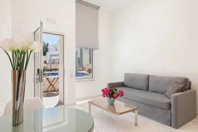 a living room with a couch and a glass table at Forum Suites in Kato Daratso