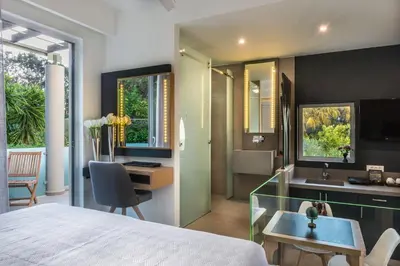 a bedroom with a bed and a desk and a sink at Forum Suites in Kato Daratso