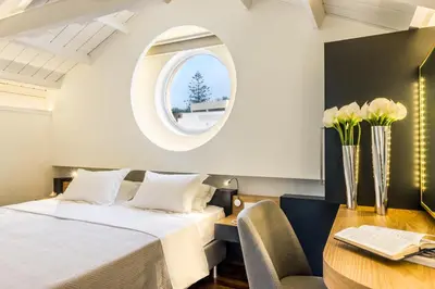 a bedroom with a bed and a round window at Forum Suites in Kato Daratso