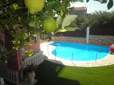 a swimming pool in a yard with a lemon tree at Dimitra's Sea-Crafts Boutique Studios in Kalyves