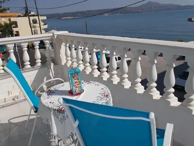 a table and chairs on a balcony with the ocean at Dimitra's Sea-Crafts Boutique Studios in Kalyves